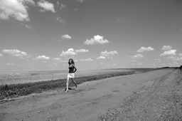 A girl walked along an empty road amongst wheat fields, Lipetsk region, 2008